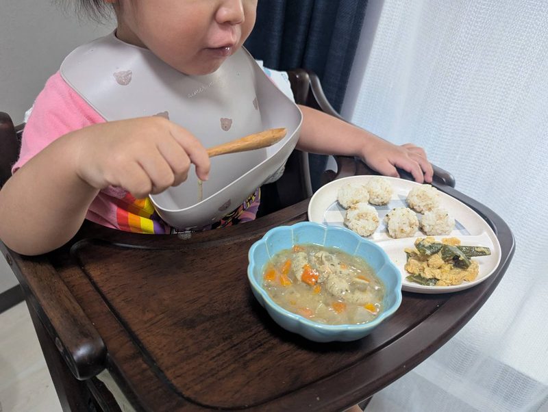 1歳半の息子がスプーンを持ったまま手が止まっている食卓の様子