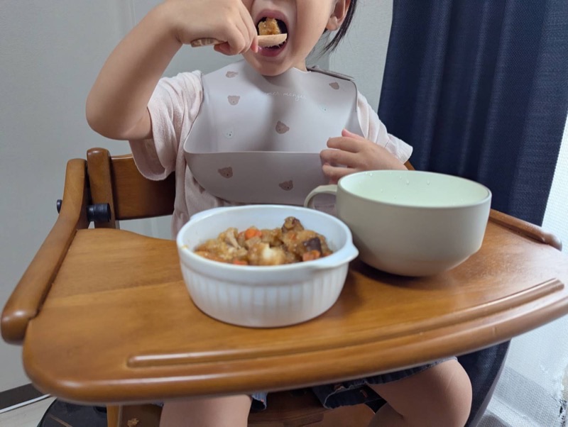 娘がキッズレーションのメニューを口に入れる様子
