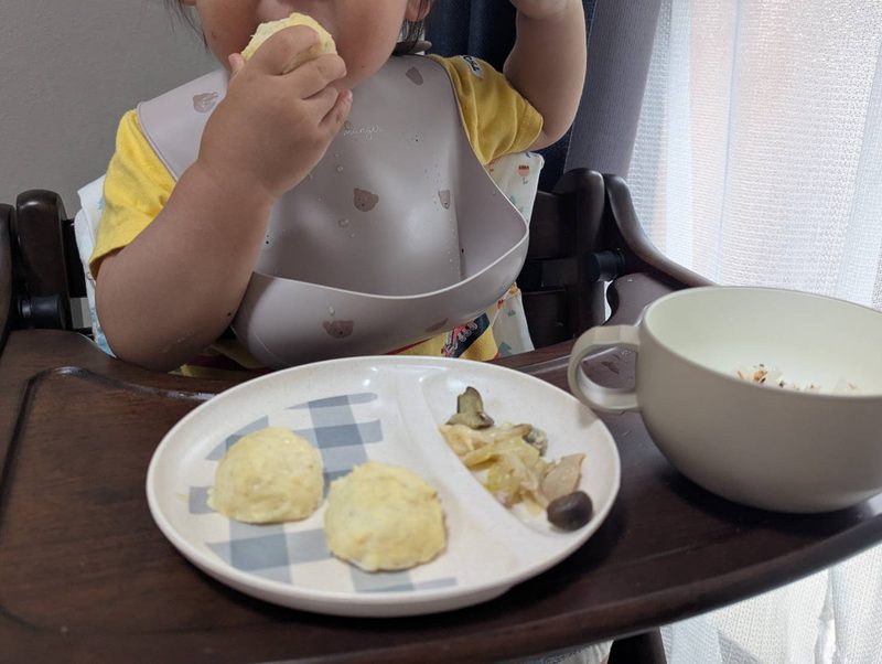 1歳半ごろの息子がてでもぐのお魚入り豆腐ハンバーグを手に持って食べている様子